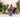 A woman in a red hoodie holds a potted plant, sitting among lush greenery with a Husky lying at her feet.