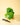A 4-inch Monstera 'Deliciosa' plant with green heart-shaped leaves, placed on a wooden surface with a pair of pruning shears beside it, against a yellow background.