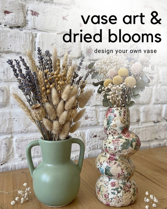 Two vases with dried florals against a white brick wall.