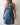 Person wearing a blue denim apron with 'BWH Plant Co' logo against a plain background