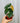 A hand holding a 4-inch Philodendron 'Melanochrysum' plant with deep green leaves and golden veins in a small red pot.