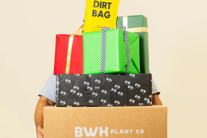 A stack of colorful wrapped gifts topped with a yellow 