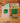 A set of stickers featuring the text 'FRAGILE AF' in green, yellow, and black, displayed on a wooden surface next to a clear plastic bag containing a green skull sticker.